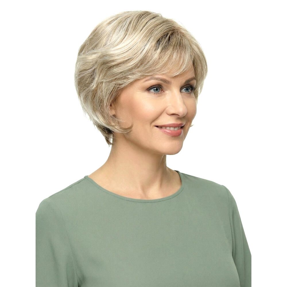 Kurzhaarperücke mit blonden Strähnen. Frau mit Perücke, Blick nach rechts. Grünes Oberteil.