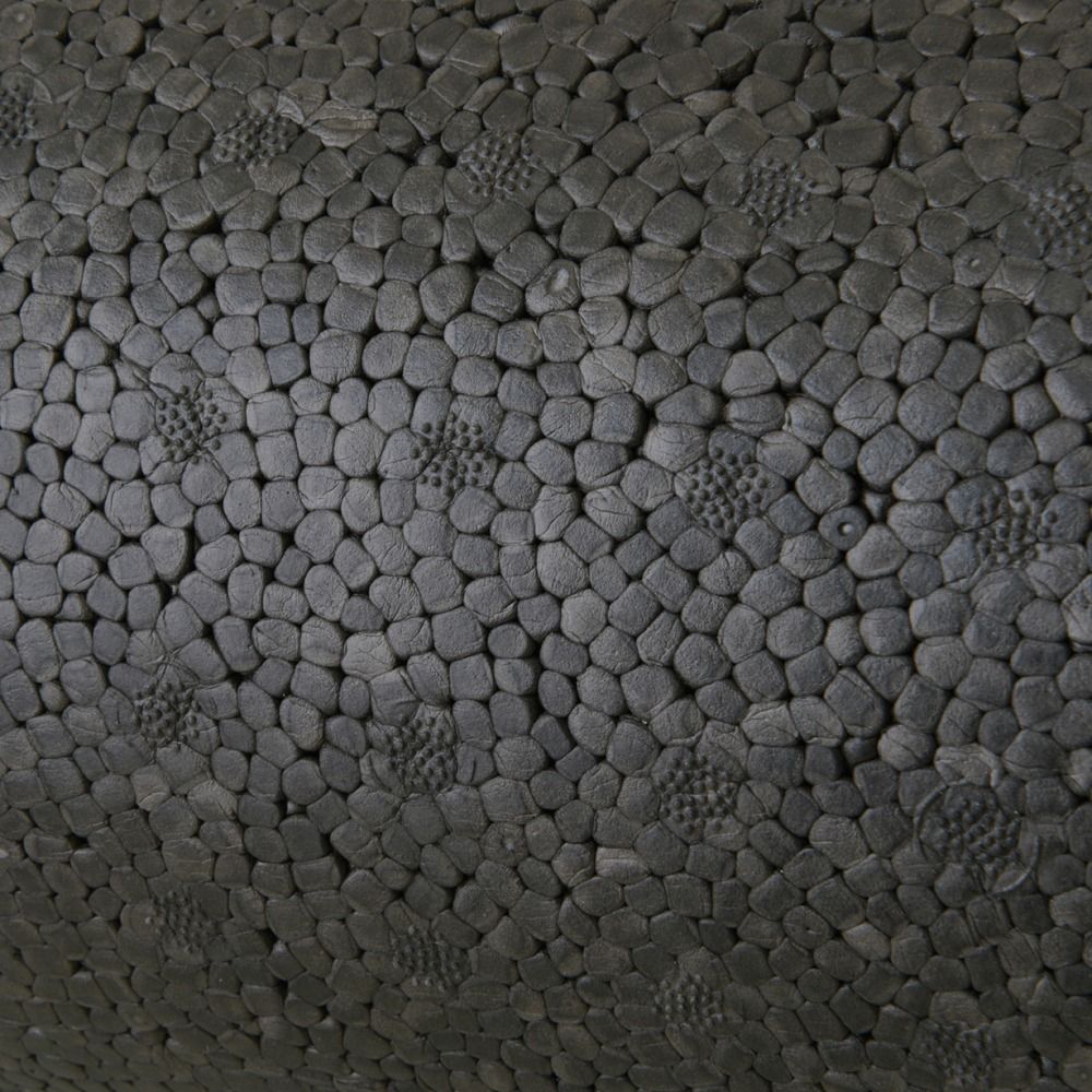 Nahaufnahme einer schwarzen Rolle. Oberfläche mit kleinen, unregelmäßigen Vertiefungen und erhabenen Mustern.