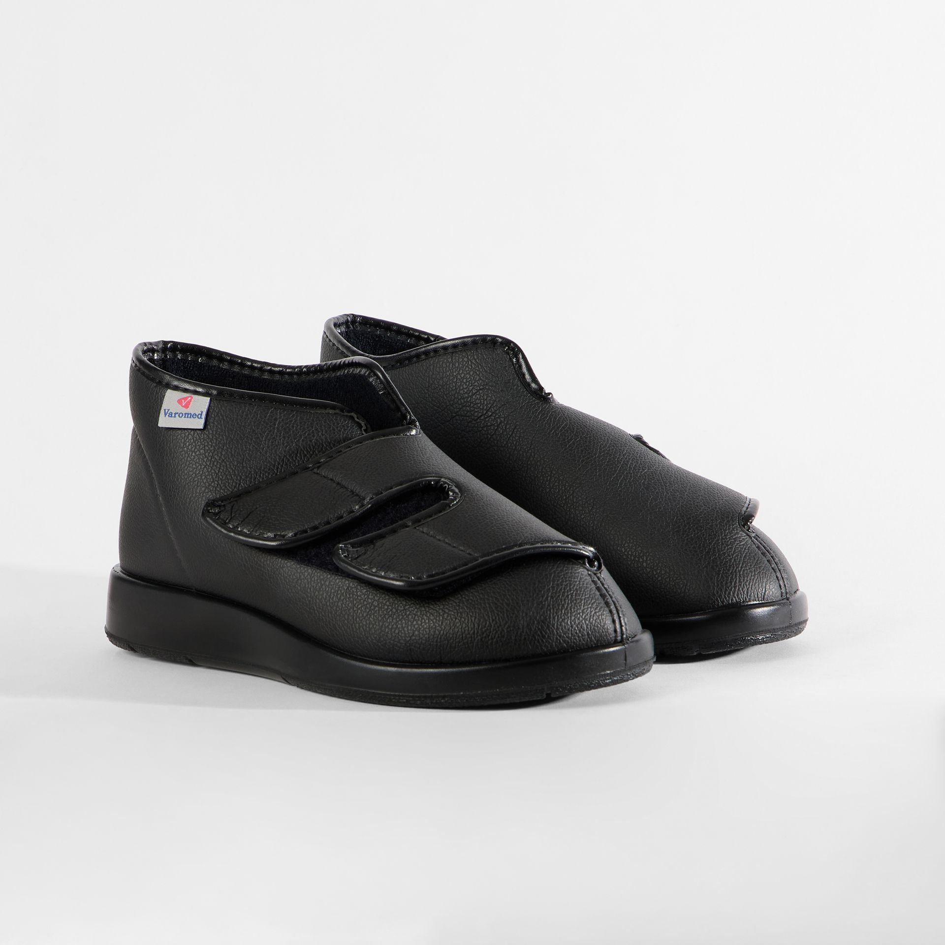 Schwarze Schuhe mit Klettverschluss und rutschfester Sohle.