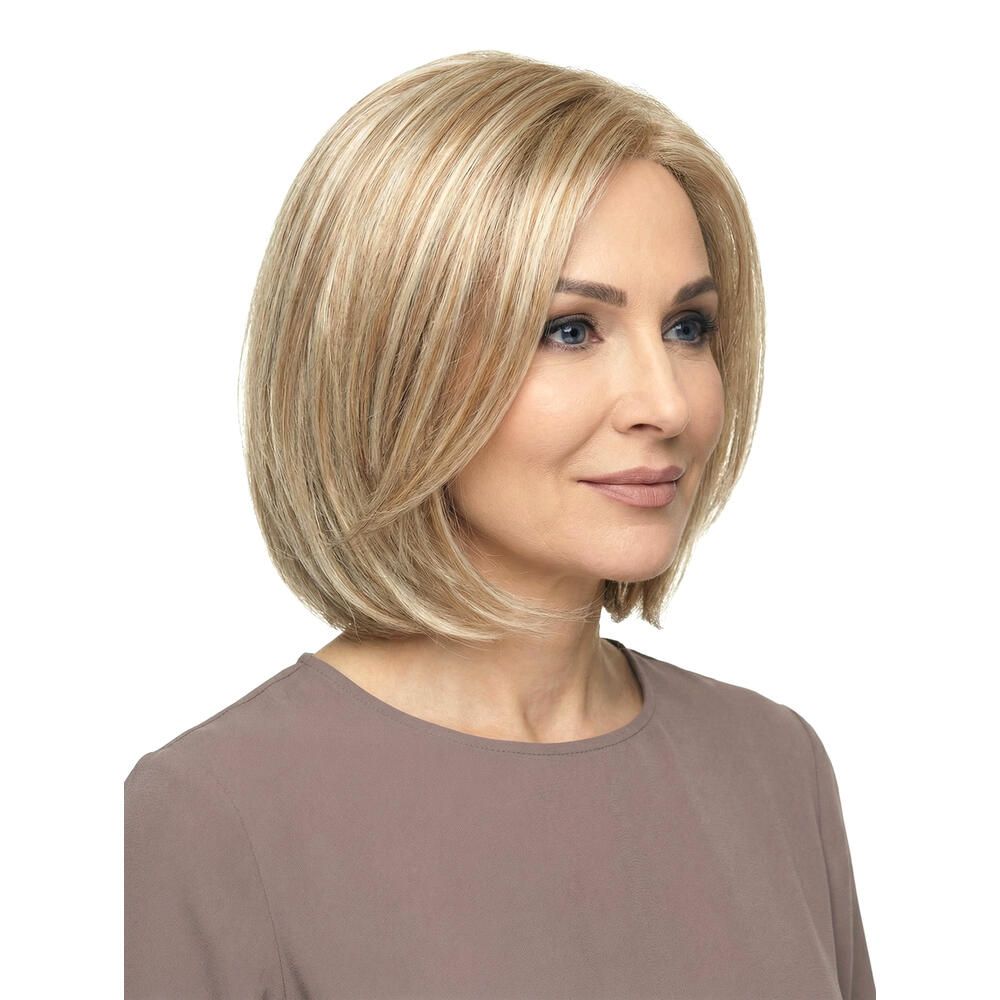 Blonde Perücke mit gestuften Haaren. Nahaufnahme einer Frau mit der Perücke. Hellbraunes Oberteil.