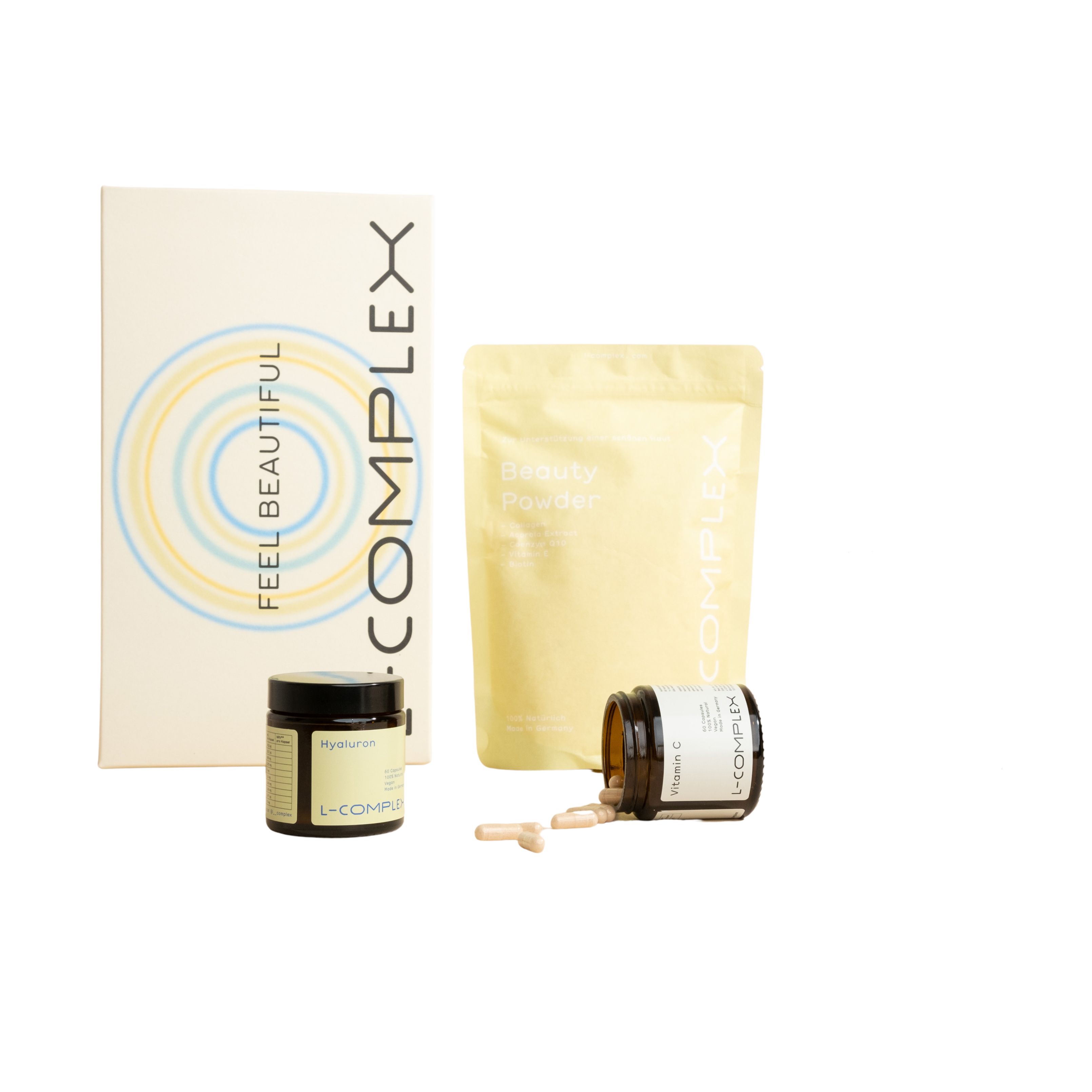 Verschiedene L-Complex Produkte: Kapseln in Glas, Beutel mit Pulver, Karton. Aufschrift: FEEL BEAUTIFUL.