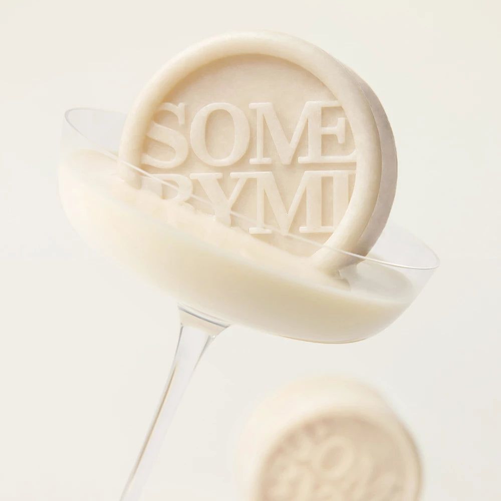 Ein Seifenstück mit dem Schriftzug SOME BYMI in einem Glas mit Flüssigkeit.