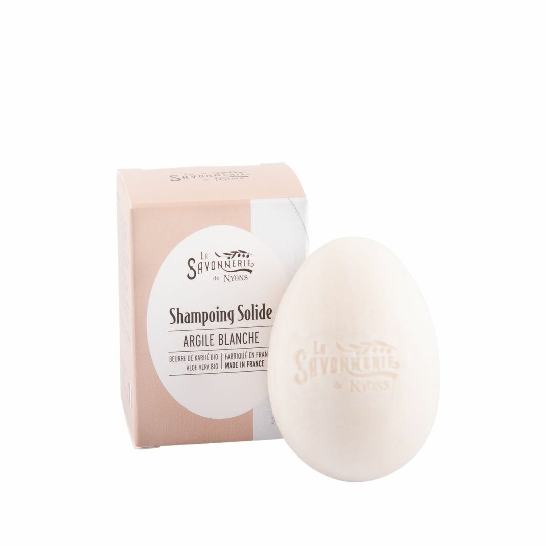 Festes Shampoo in Kartonverpackung. Weißer Ton, ovale Form. Text: La Savonnerie de Nyons, Shampoing Solide Argile Blanche.