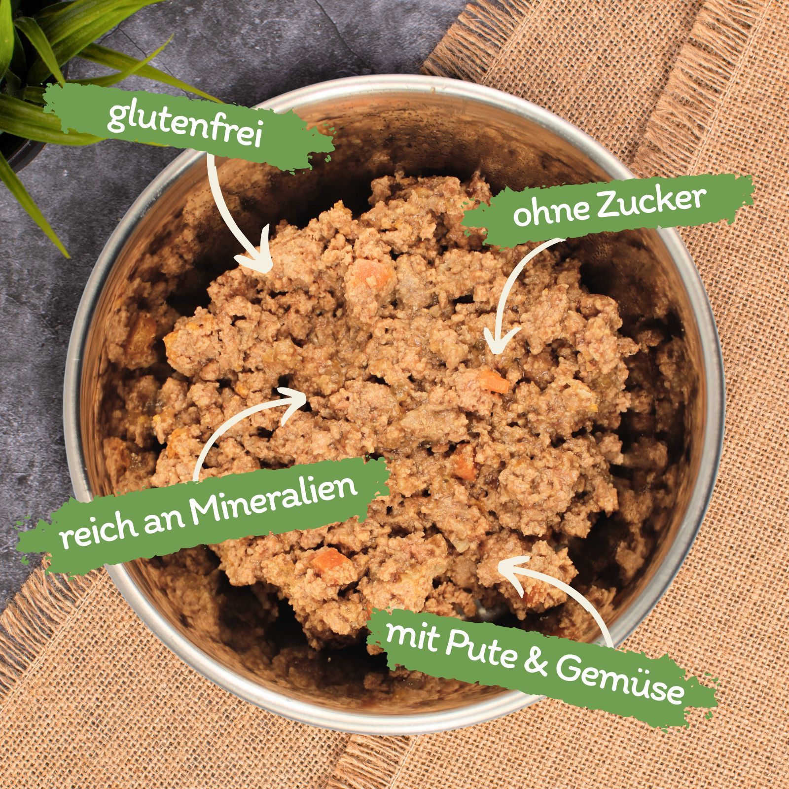 Metallschale mit feuchtem Tierfutter, gekennzeichnet als glutenfrei, zuckerfrei, mineralstoffreich, mit Pute und Gemüse.