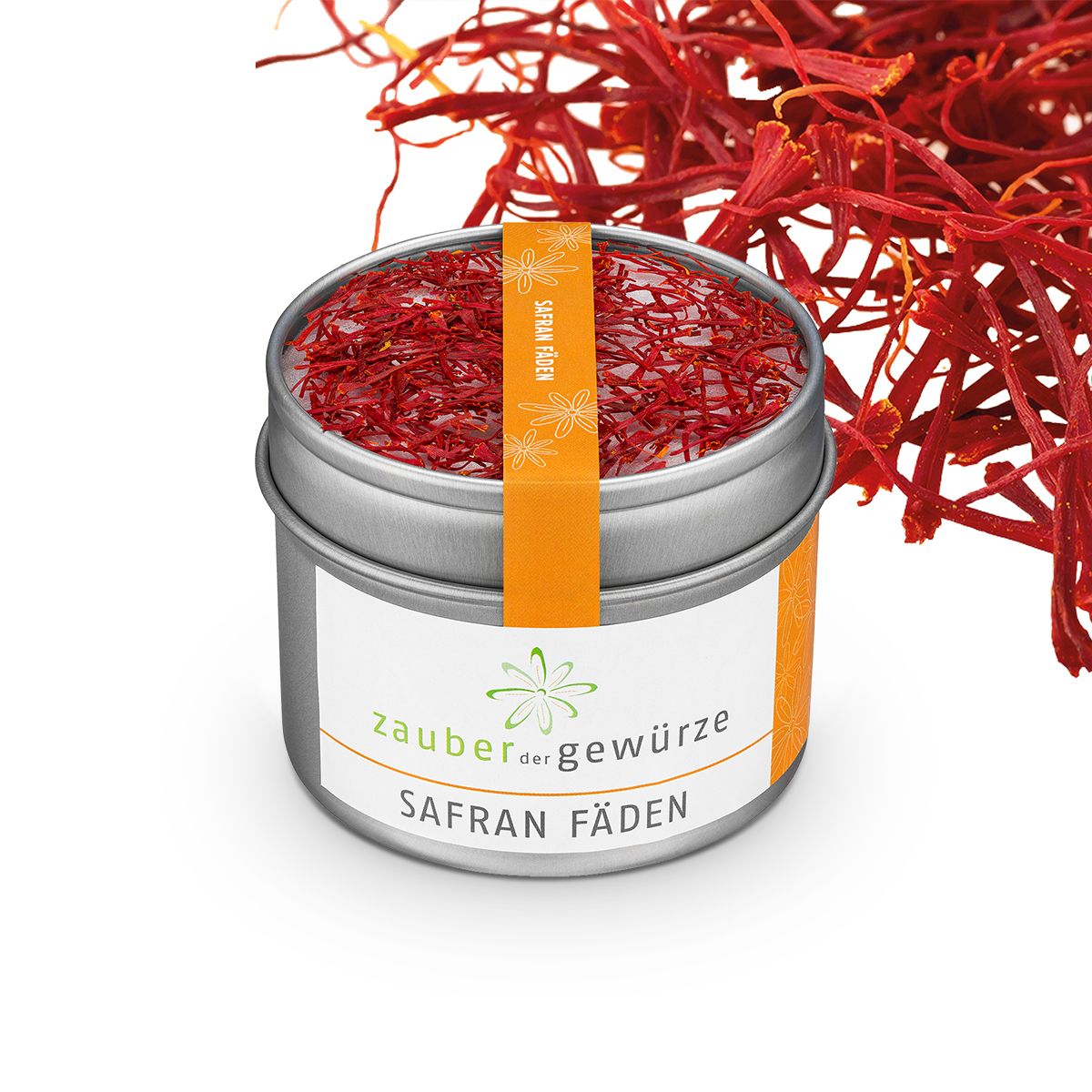 Runde Dose mit Safran-Fäden. Orangefarbenes Etikett mit "SAFRAN FÄDEN". Safran-Fäden liegen daneben. Weißes Etikett mit "zauber der gewürze".