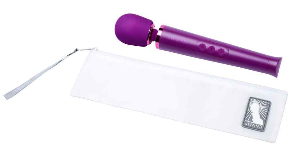 Lila Massagegerät und Aufbewahrungstasche. Zylindrischer Griff mit drei Knöpfen. Abgerundeter Kopf. Tasche mit Logo.