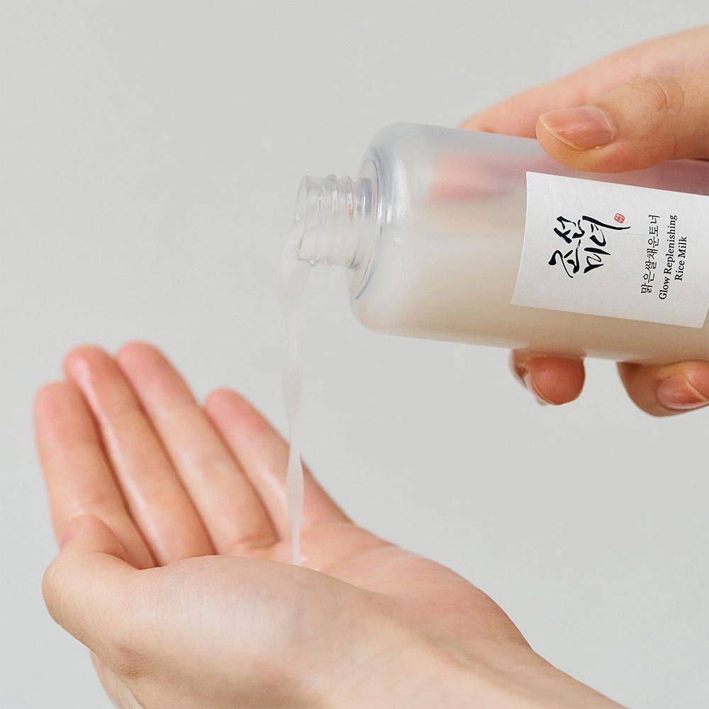 Flüssigkeit wird aus einer Flasche in eine offene Handfläche gegossen.