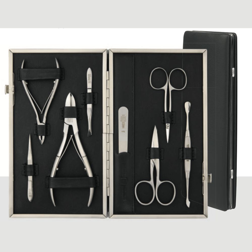 Rahmenetui mit Maniküre-Werkzeugen. Enthält zwei Zangen, zwei Scheren, Feile, Pinzette und weitere Instrumente. Schwarzes Lederetui.