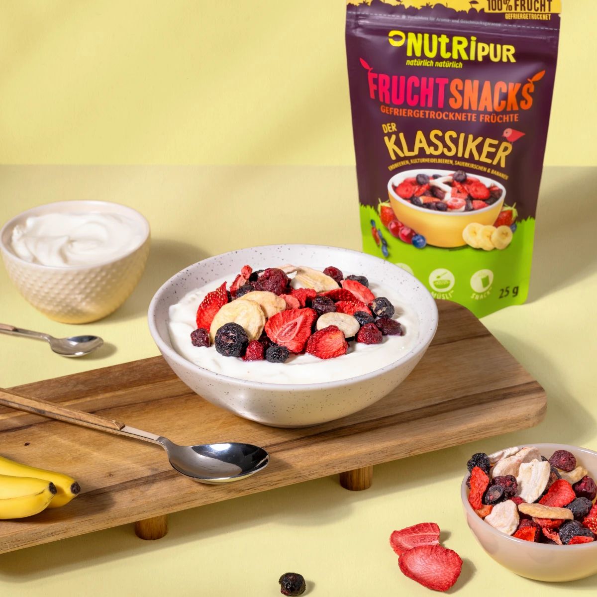 Schale mit Früchten und Joghurt. Daneben eine Packung gefriergetrocknete Früchte. Aufschrift: NutriPur, Frucht Snacks.