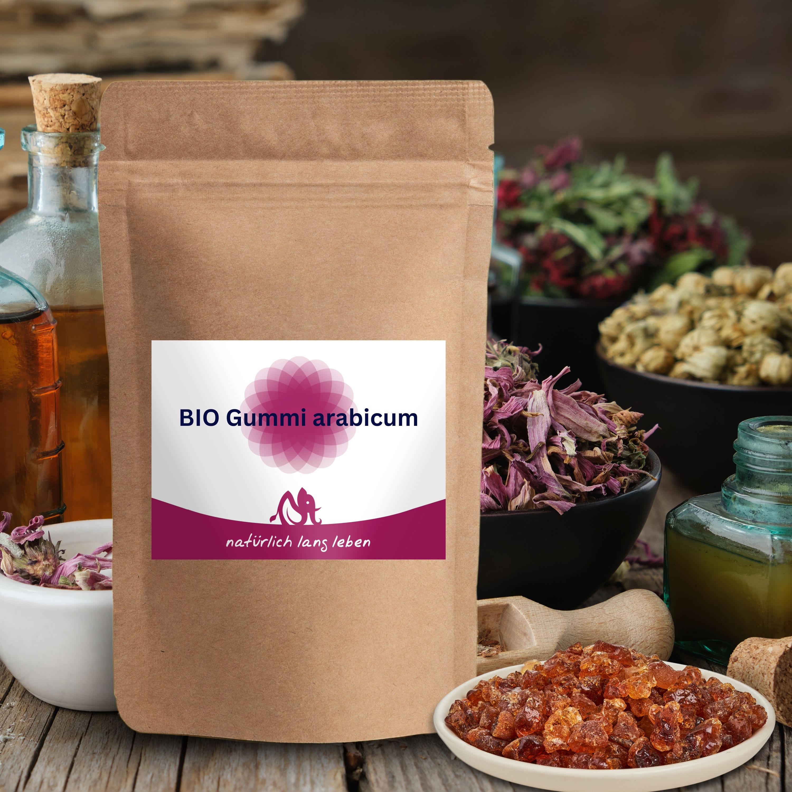 Braune Papierverpackung mit Etikett: BIO Gummi arabicum. Logo: natürlich lang leben. Auf Holzuntergrund mit weiteren Zutaten.