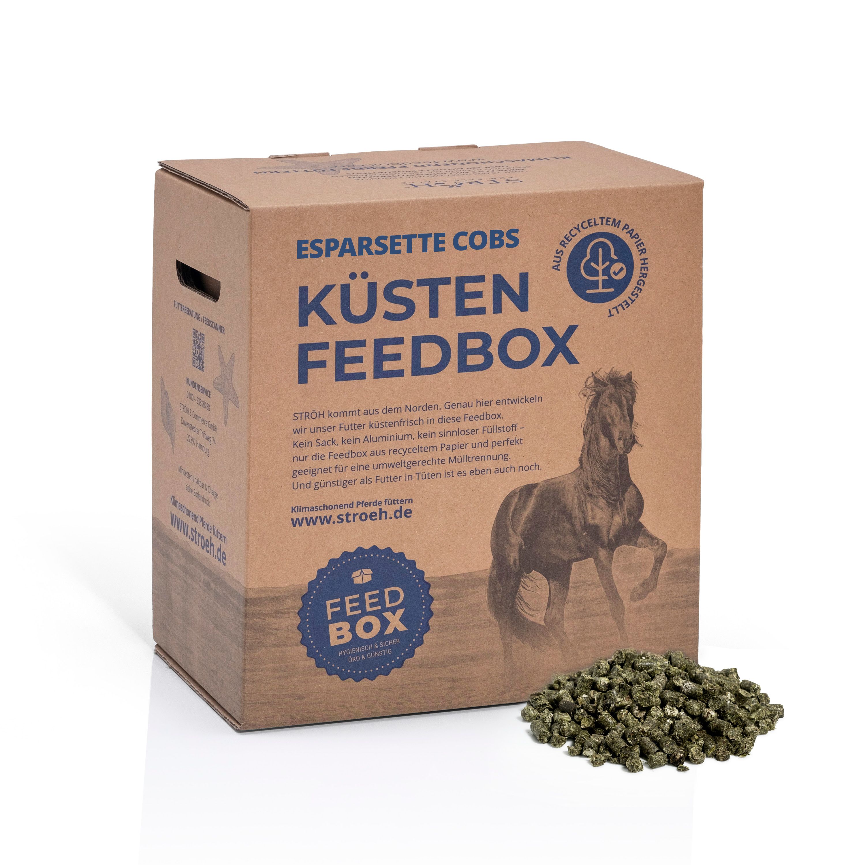 Karton mit Esparsette Cobs, Küsten Feedbox. Text: Aus recyceltem Papier. Grüne Cobs daneben. Logo.