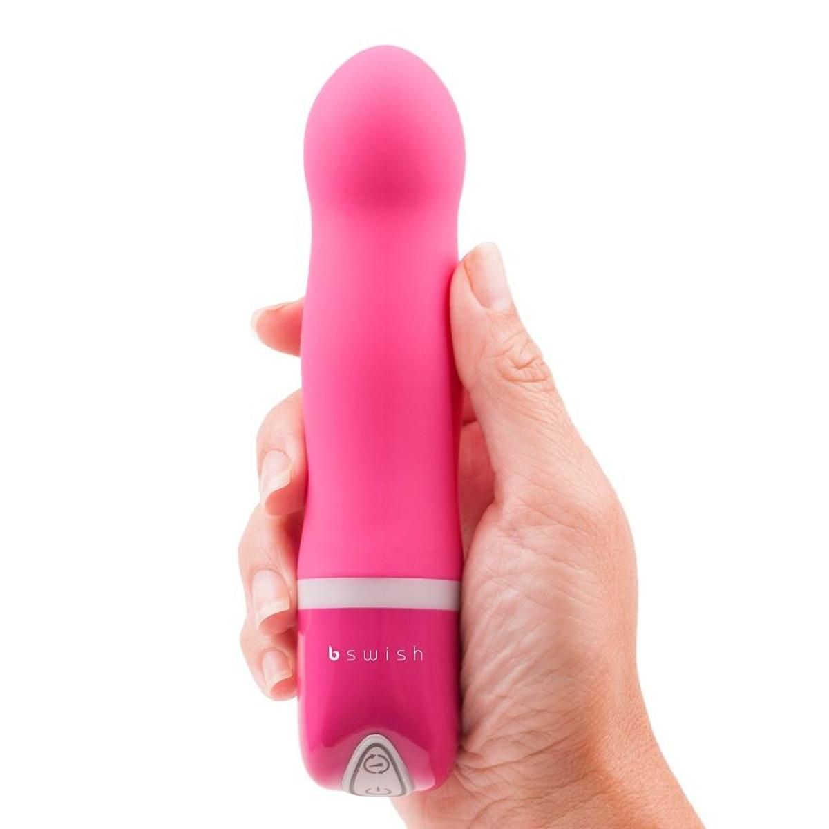 Pinkfarbener Minivibrator in einer Hand gehalten. Weißer Ring und Logo 'bswish' sichtbar. Auf weißem Hintergrund.