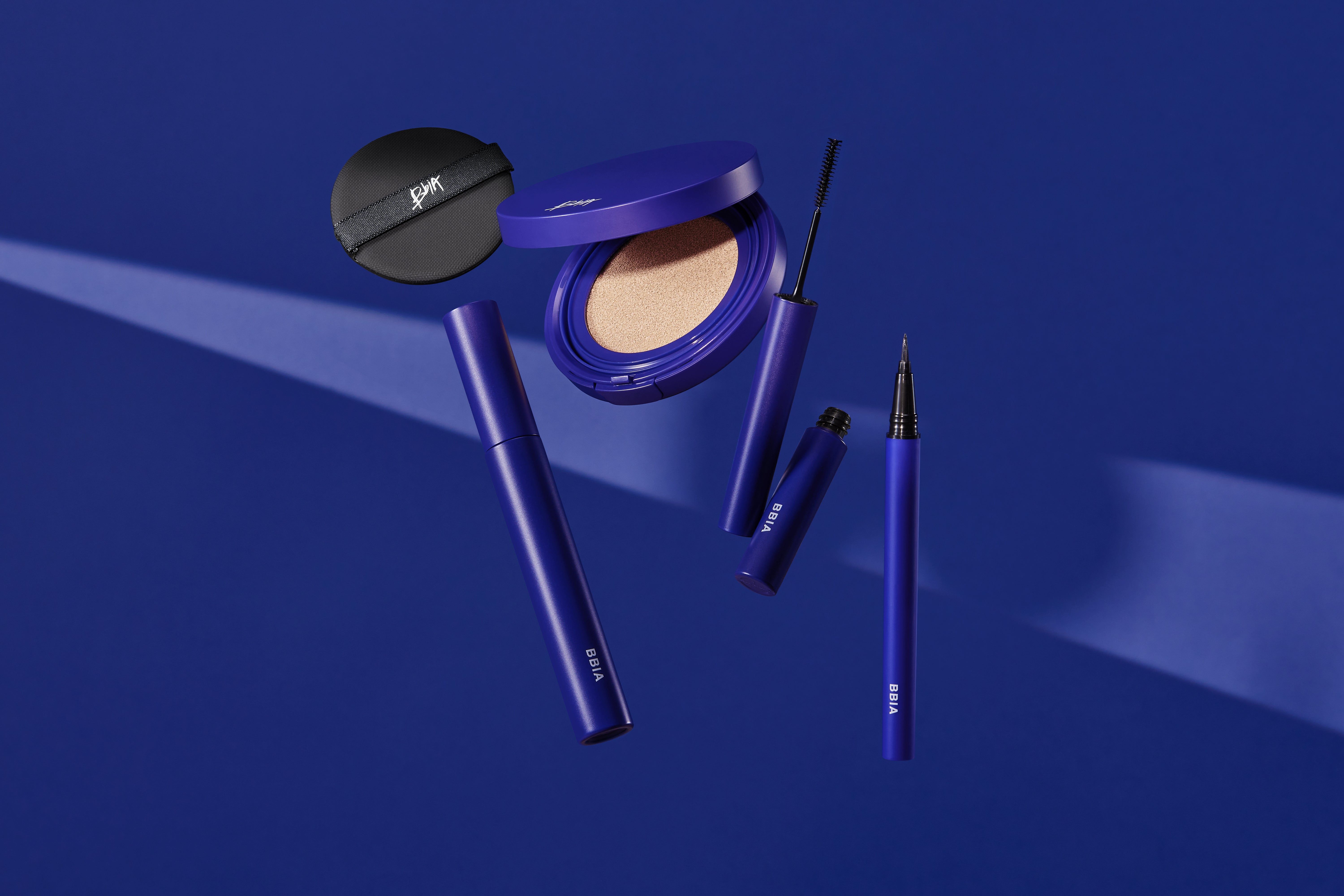 Kosmetik-Set mit verschiedenen Produkten in Blau. Enthält Eyeliner, Puder, Mascara und Schwamm. BBIA-Logo.