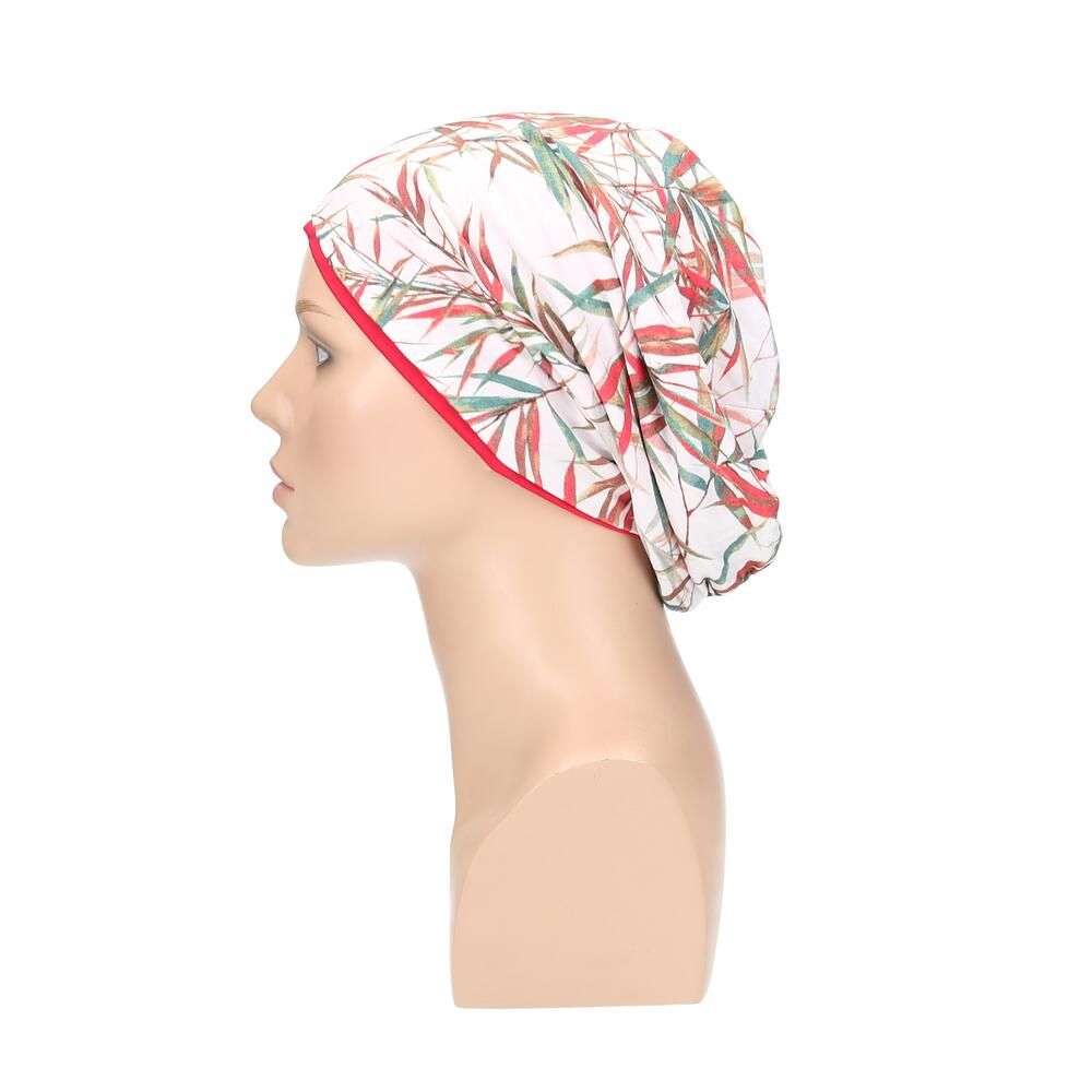 Beanie mit floralem Muster, roter Rand, auf Büste. Seitenansicht.