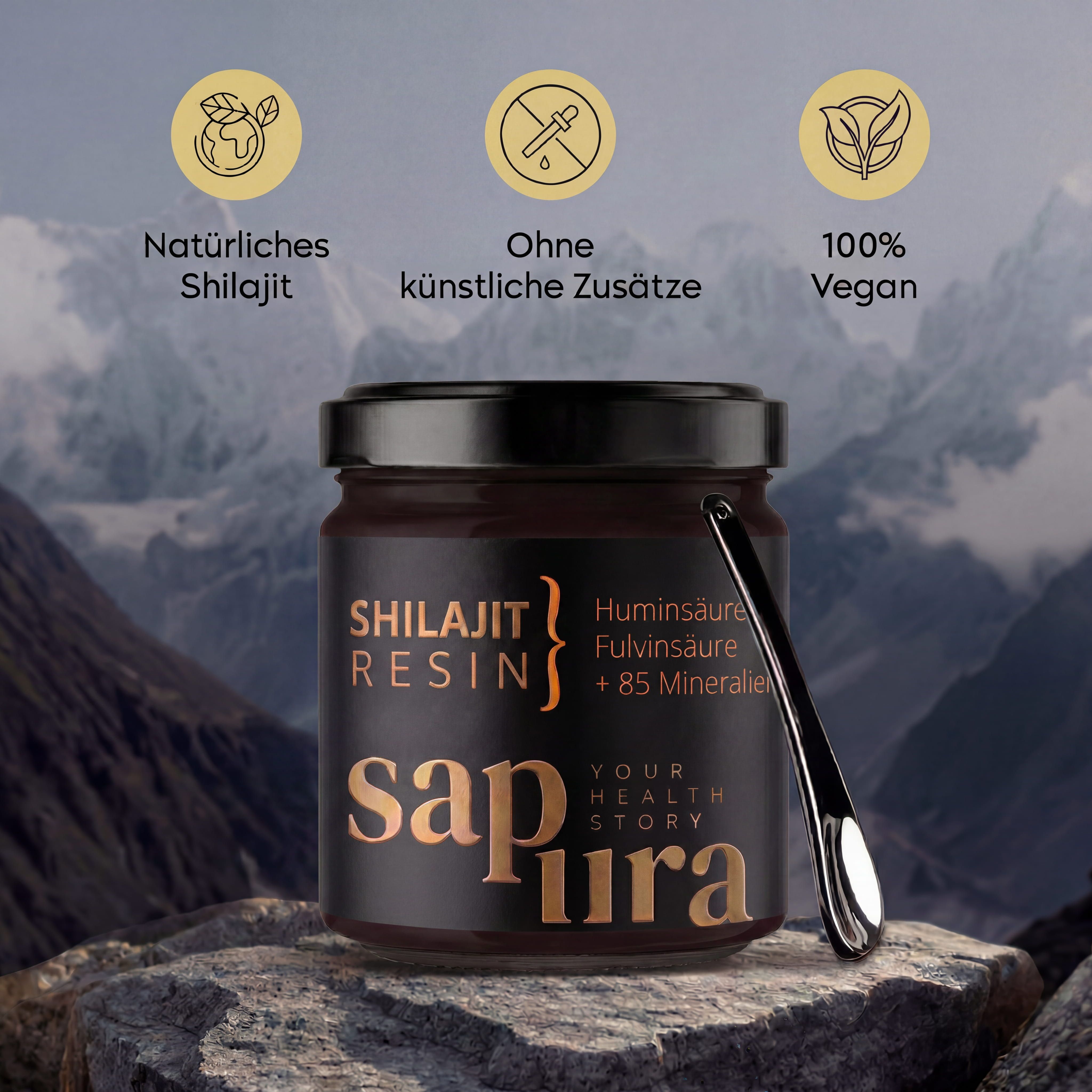 Shilajit Resin im Glas mit Dosierlöffel, vor Berglandschaft, mit Icons für 'Natürlich', 'Ohne Zusätze', 'Vegan'.