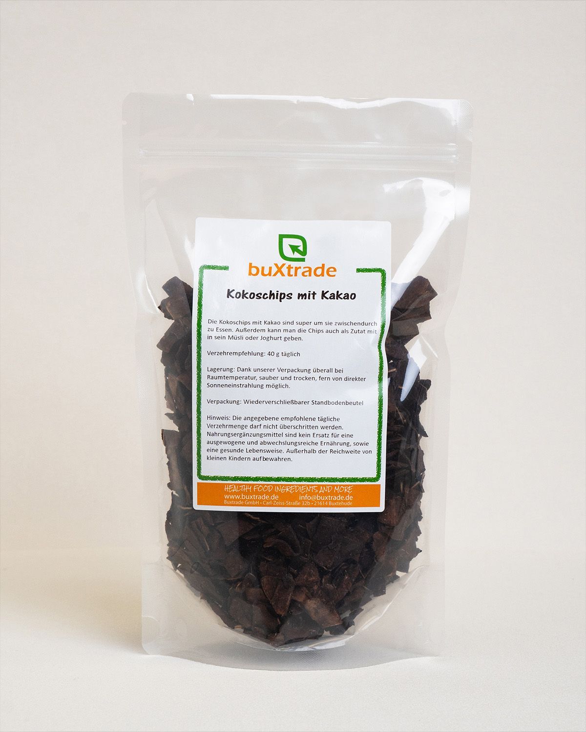Klare Tüte mit "buXtrade Kokoschips mit Kakao". Produkt in der Tüte sichtbar. Weißer Hintergrund.