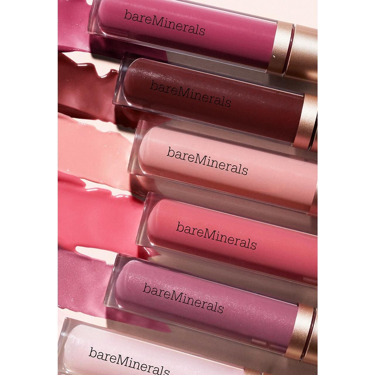 Mehrere Lipgloss-Tuben mit goldfarbenen Deckeln. Auf den Tuben steht "bareMinerals".