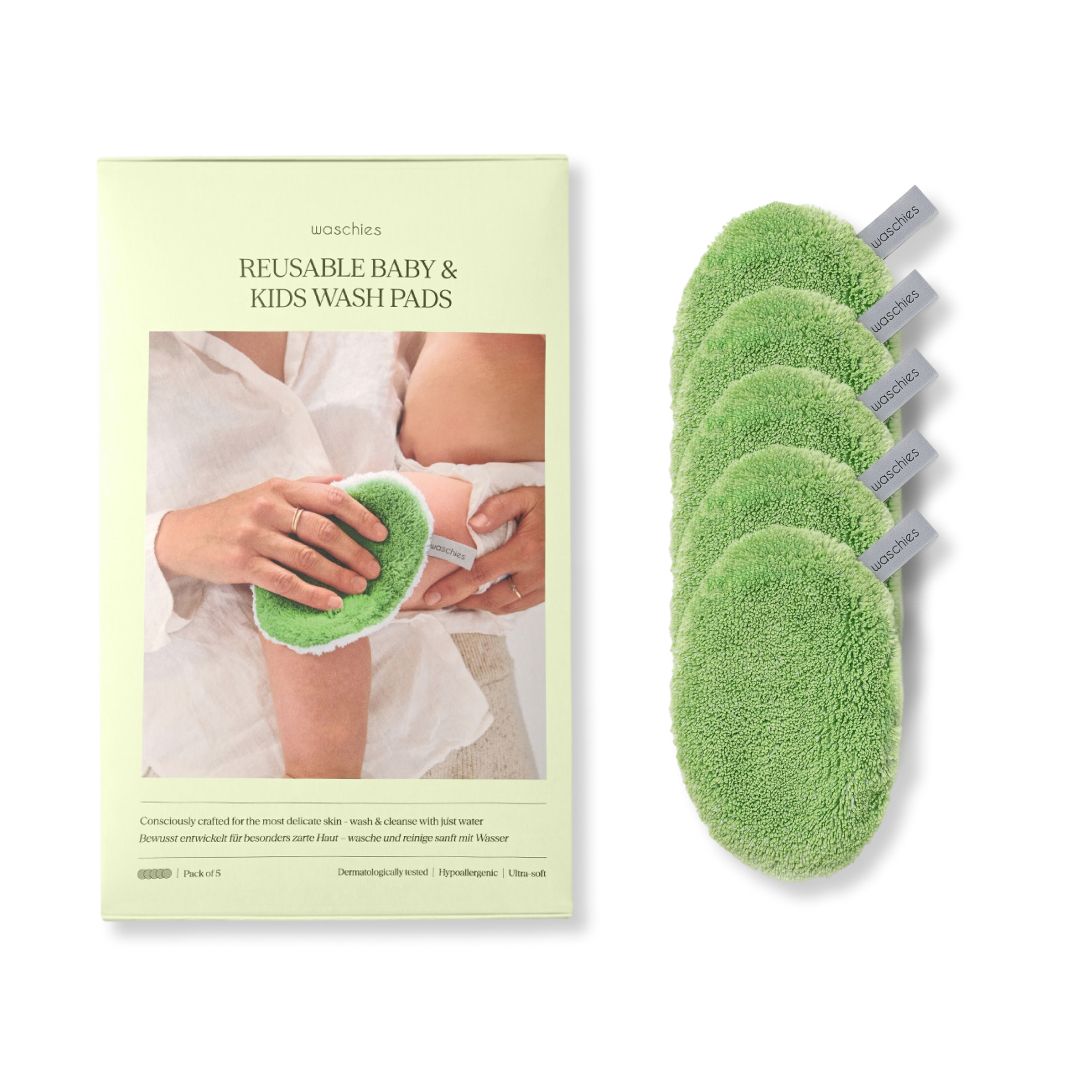 Grüne Waschpads für Babys und Kinder, neben einer Verpackung. Auf der Verpackung ist ein Babyarm abgebildet, der mit einem Pad gereinigt wird.