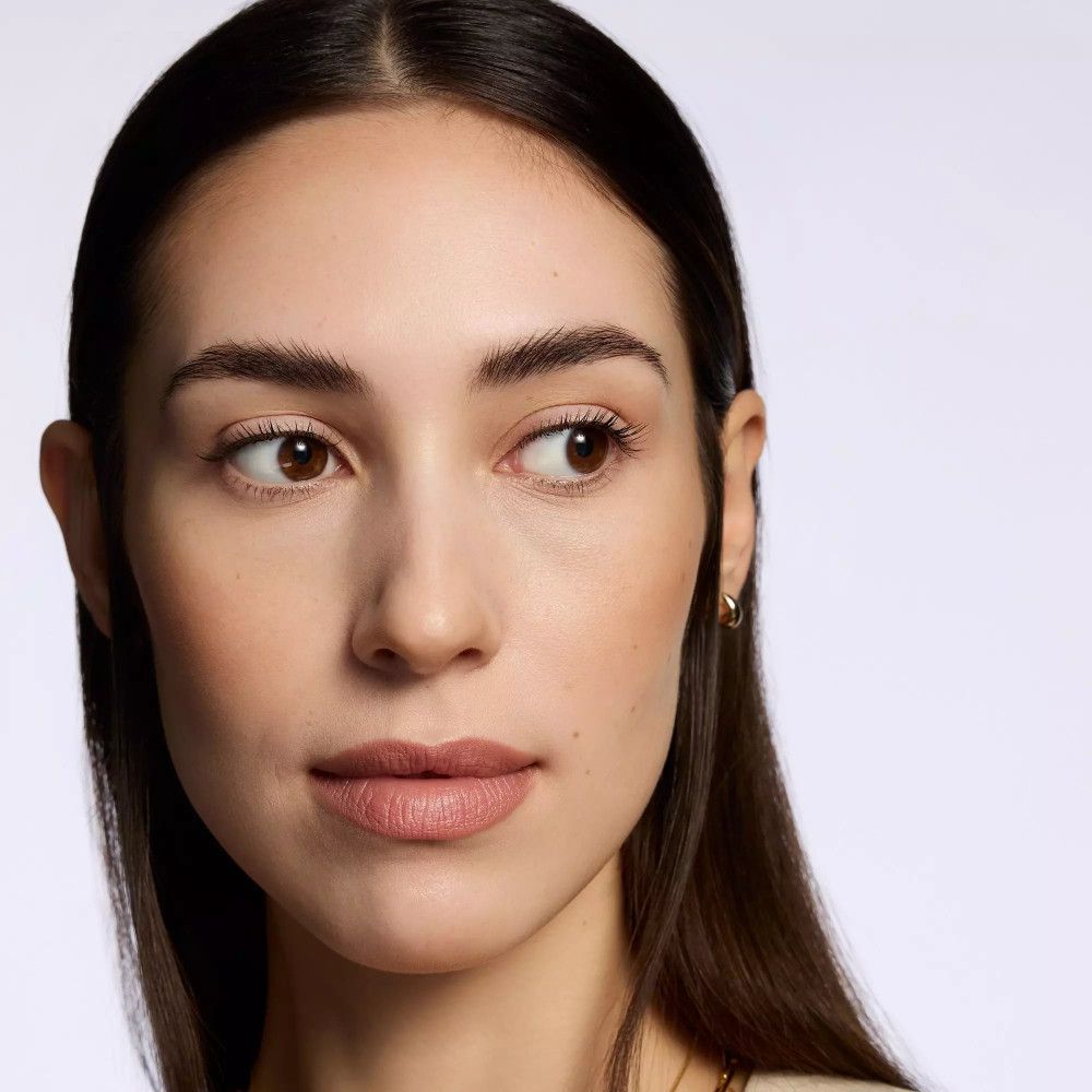 Porträt einer Frau mit Lippenstift. Sie schaut zur Seite.