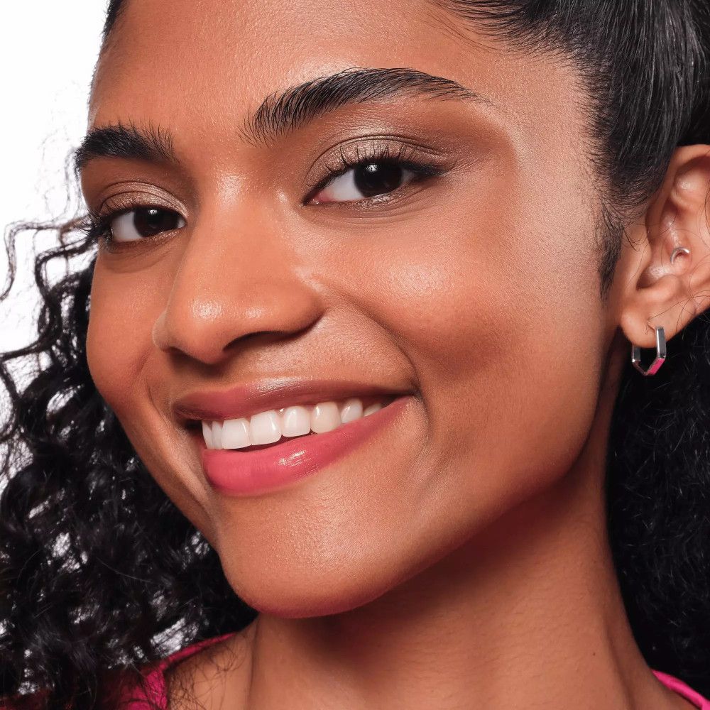 Nahaufnahme einer Frau mit braunem Lidschatten auf den Augenlidern. Sie lächelt.