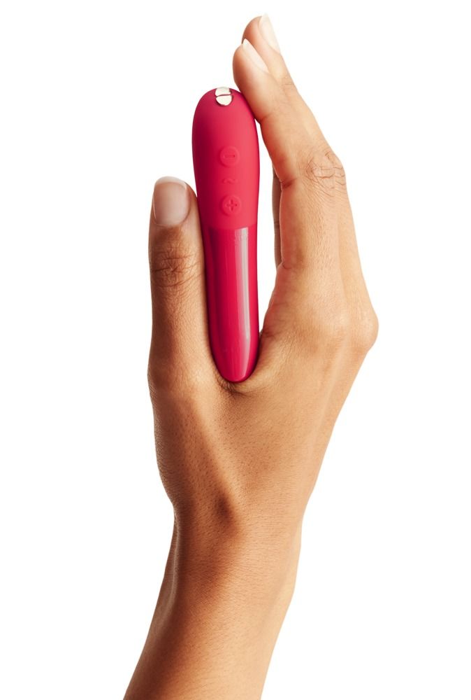 Roter Vibrator in einer Hand gehalten. Die Hand umschließt das Produkt. Weißer Hintergrund.