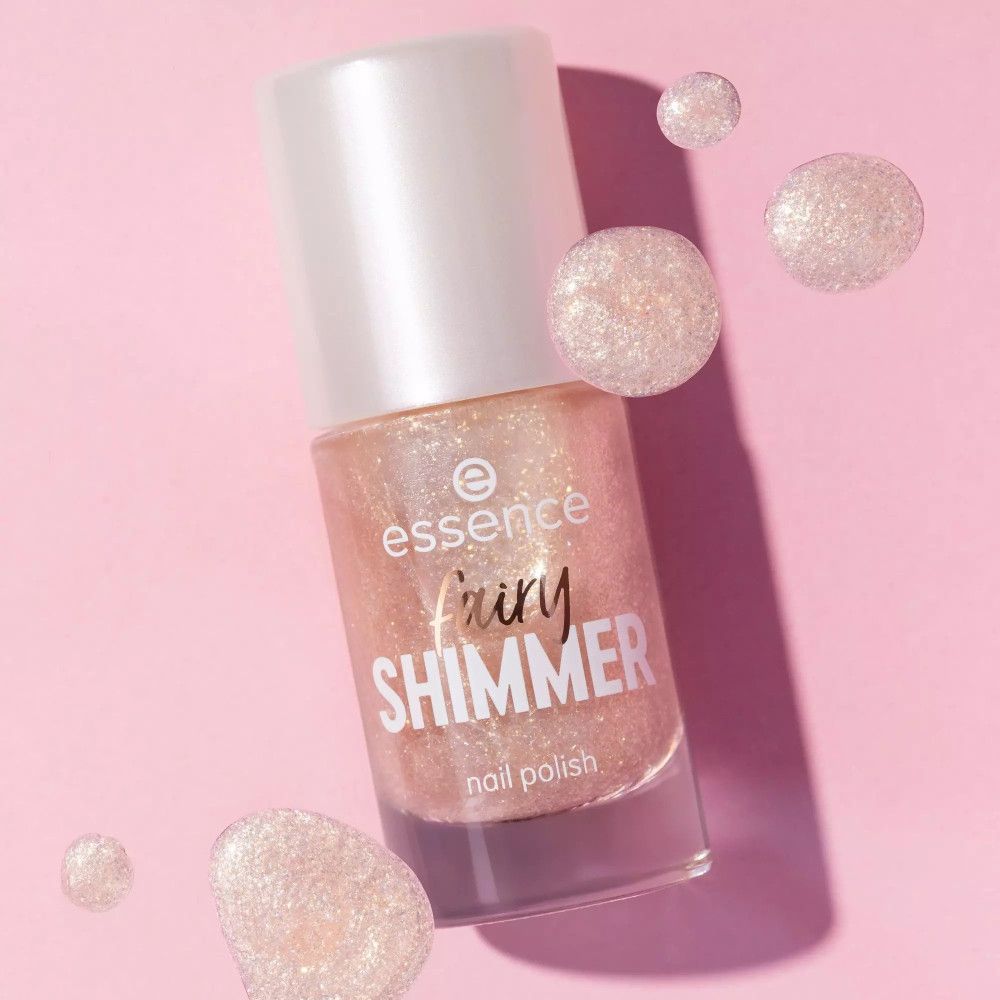 Essence Fairy Shimmer Nagellack, rosa schimmernd, mit rosa Hintergrund und schimmernden Kugeln.