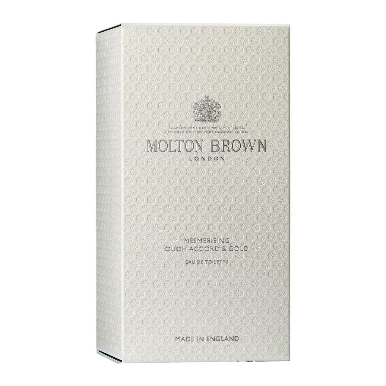 Weiße Schachtel mit Prägemuster und Logo. Aufschrift: Molton Brown London, Mesmerising Oudh Accord & Gold.