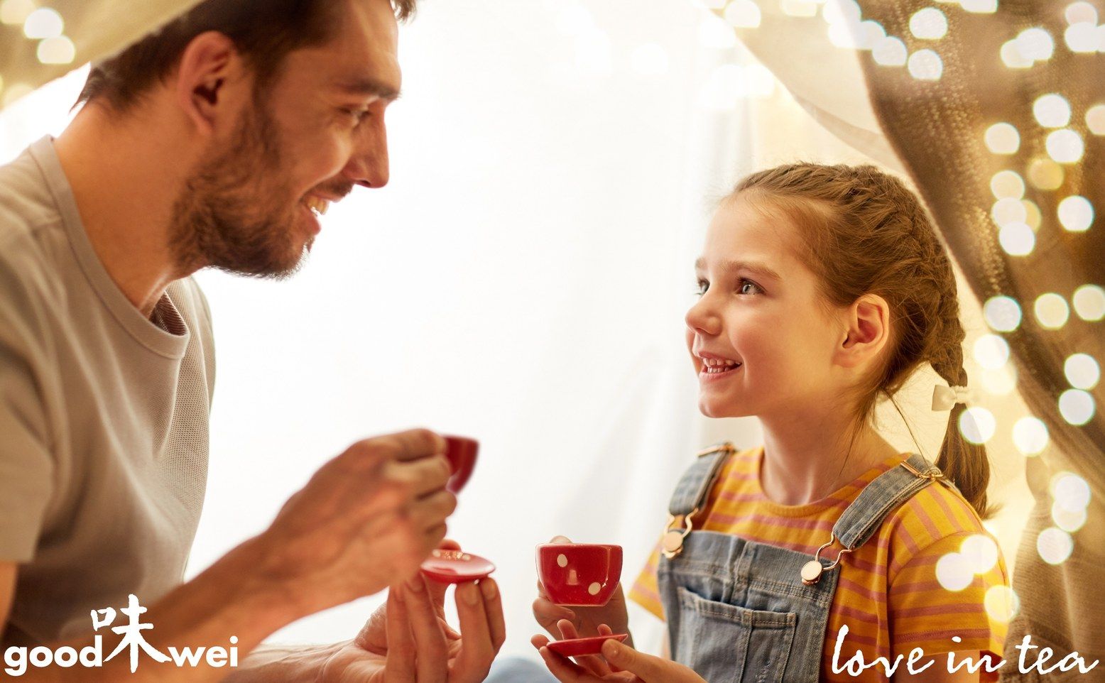 Mann und Mädchen trinken Tee aus roten Tassen. Logo "goodwei" unten links. Text "love in tea" rechts.