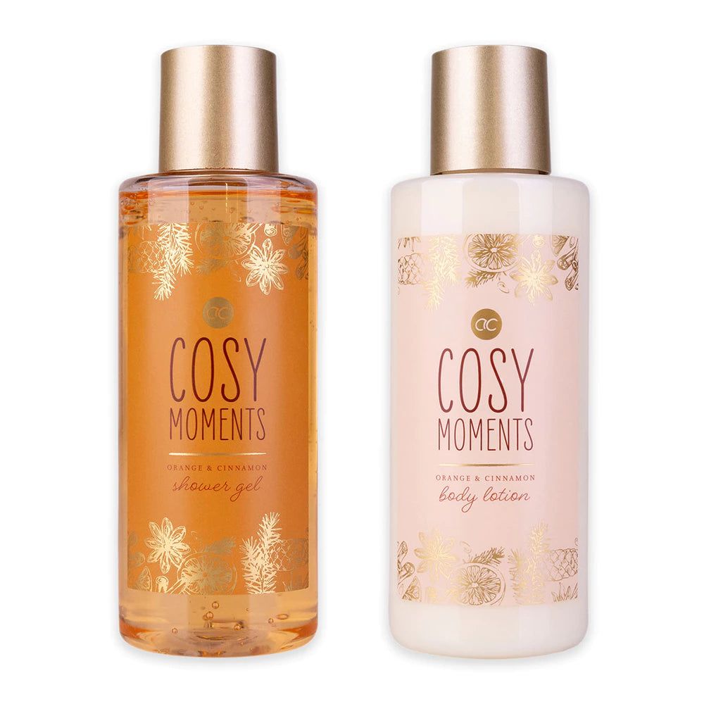 Zwei Flaschen mit goldenen Deckeln. Aufschrift "Cosy Moments Orange & Cinnamon". Eine Flasche Duschgel, eine Lotion.