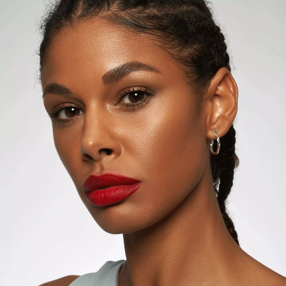 Nahaufnahme von Lippen, die mit rotem Lippenstift bemalt sind. Die Lippen sind voll und glänzend.