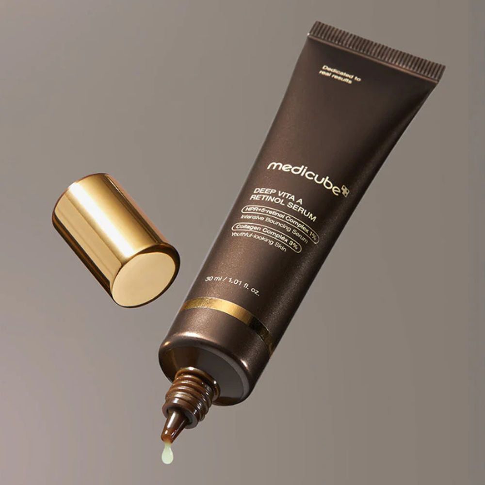 Braune Tube, goldfarbener Deckel daneben. Aufschrift: Medicube Deep Vita A Retinol Serum. Tropfen Serum.