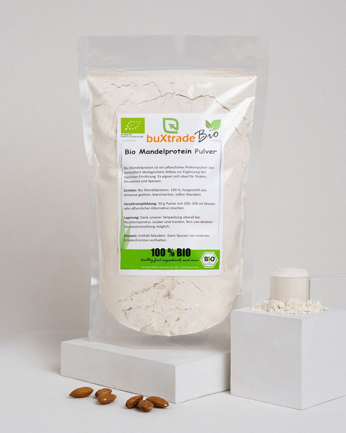 Bio Mandelprotein Pulver mit Mandeln, Löffel und kleinem Behälter mit Pulver.