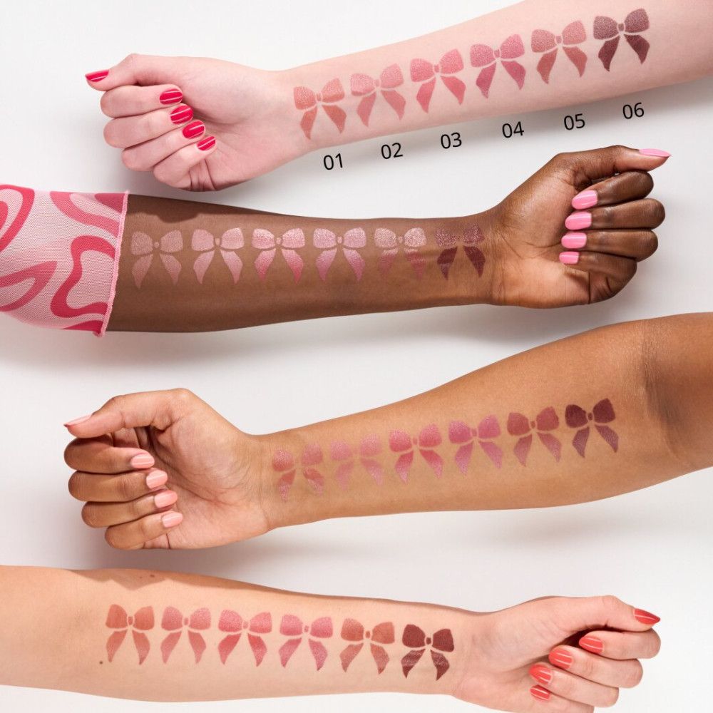 Arme mit Lippenstift-Swatches in verschiedenen Rosatönen. Sechs Swatches pro Arm, in Form von Schleifen.