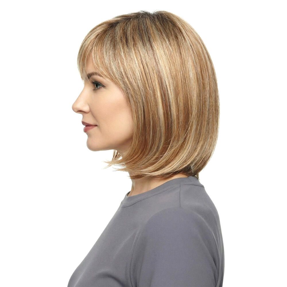 Perücke Mola von trendhair. Blond-braune Haarfarbe mit Pony. Mittellange, gestufte Frisur. Frau trägt graues Oberteil.