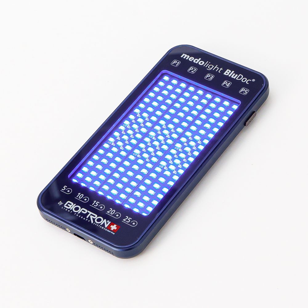 Blaues medolight BluDoc-Gerät. Rechteckig, mit blauen LEDs. Zeigt Zeitangaben und Bioptron-Logo.
