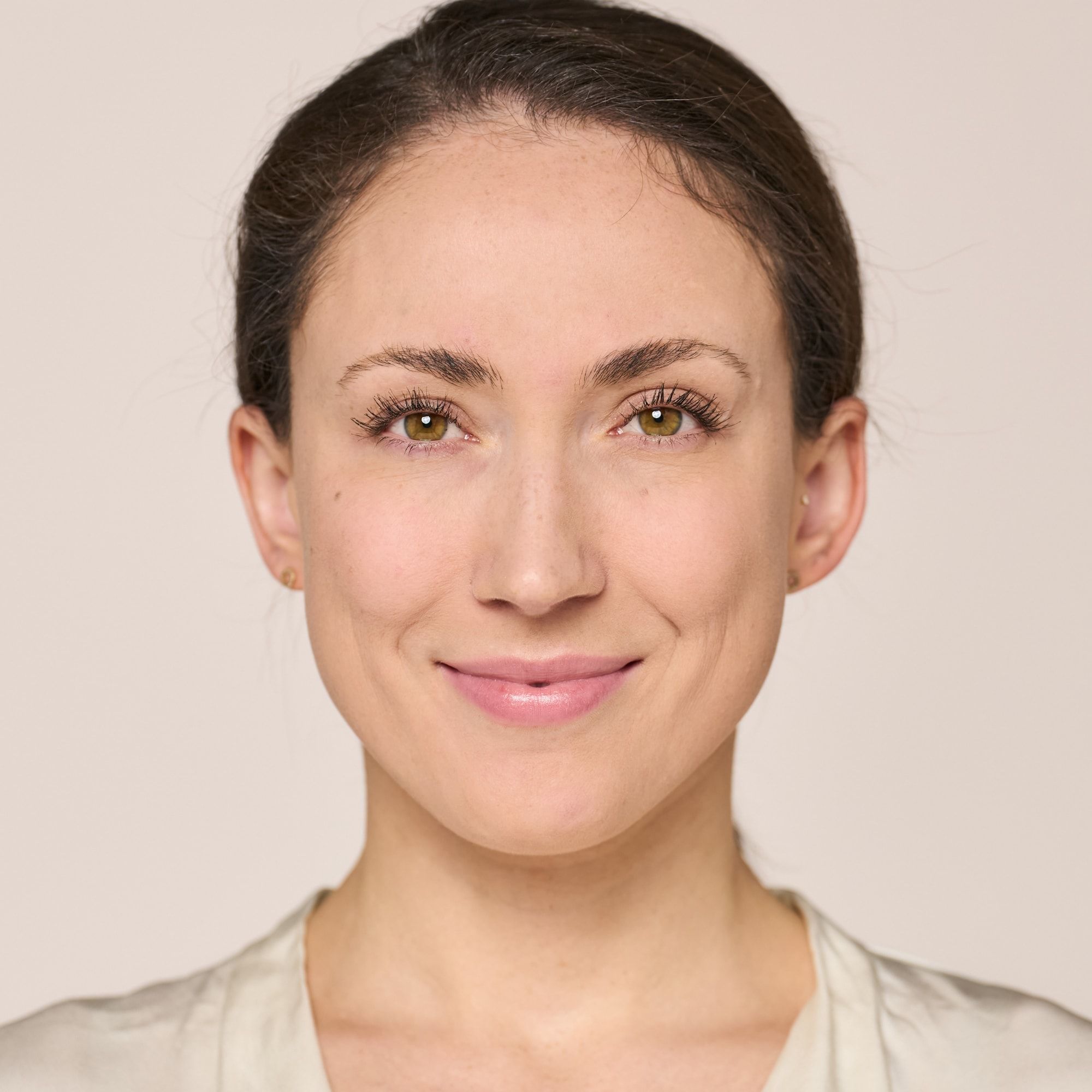 Porträt einer Frau mit leichtem Make-up und einem Lächeln.