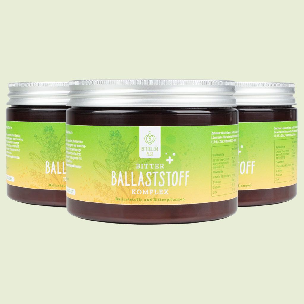 Drei Dosen mit gelb-grünem Etikett. Text: BitterLiebe Ballaststoff Komplex. Auf grünem Hintergrund.