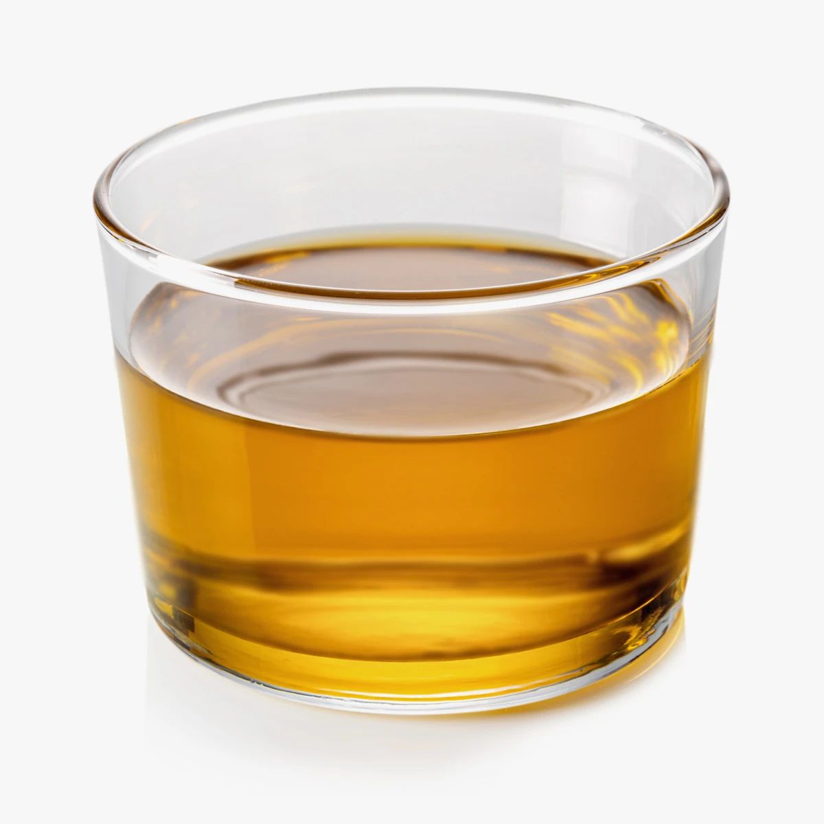 Glas mit gelber Flüssigkeit. Klare, runde Form. Flüssigkeit steht im Glas.