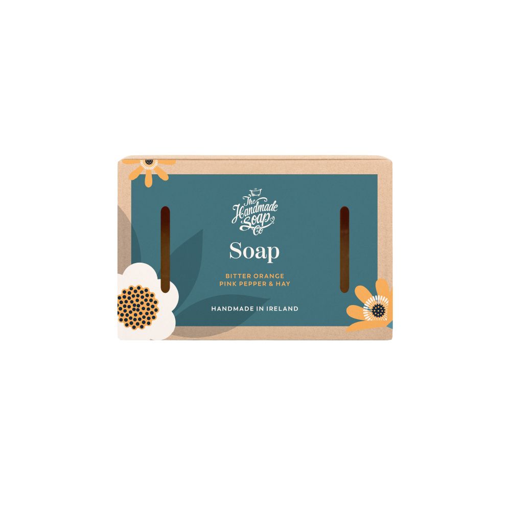 Seife in Verpackung. Aufschrift: The Handmade Soap, Soap, Bitter Orange, Pink Pepper & Hay. Hergestellt in Irland. Blumen-Dekoration.