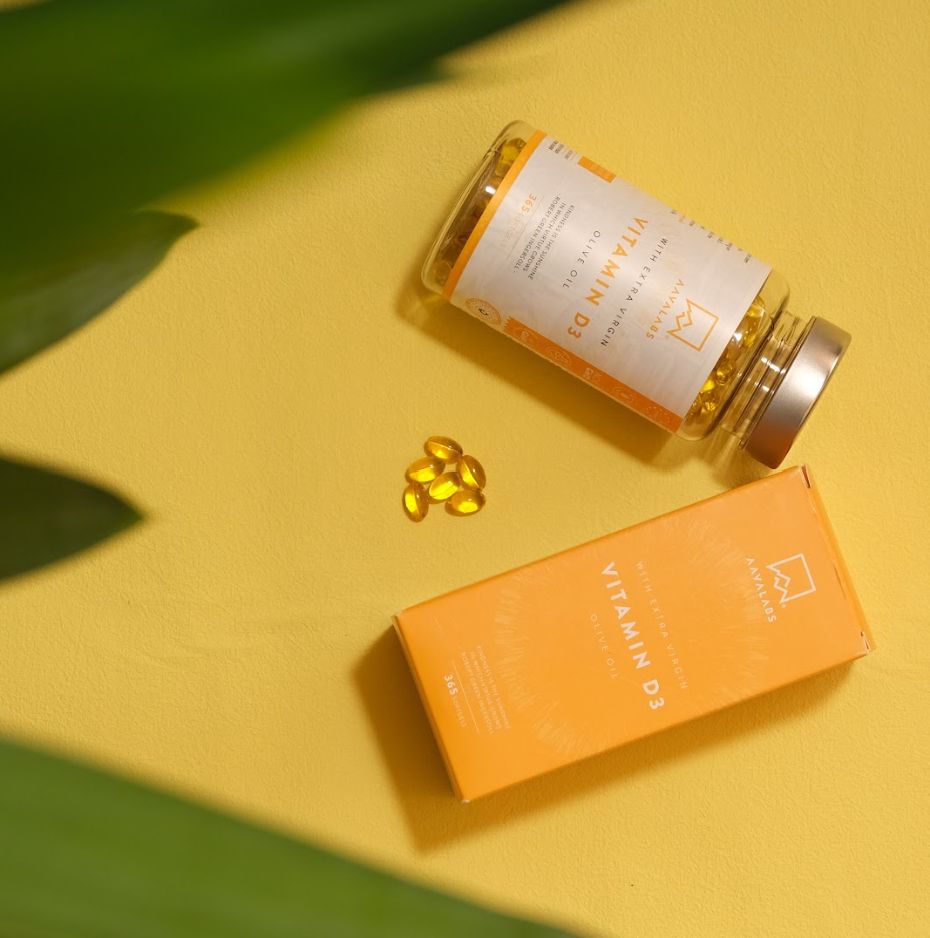 Vitamin D3-Flasche und Schachtel auf gelbem Hintergrund. Aufschrift: AAVALABS, Vitamin D3.