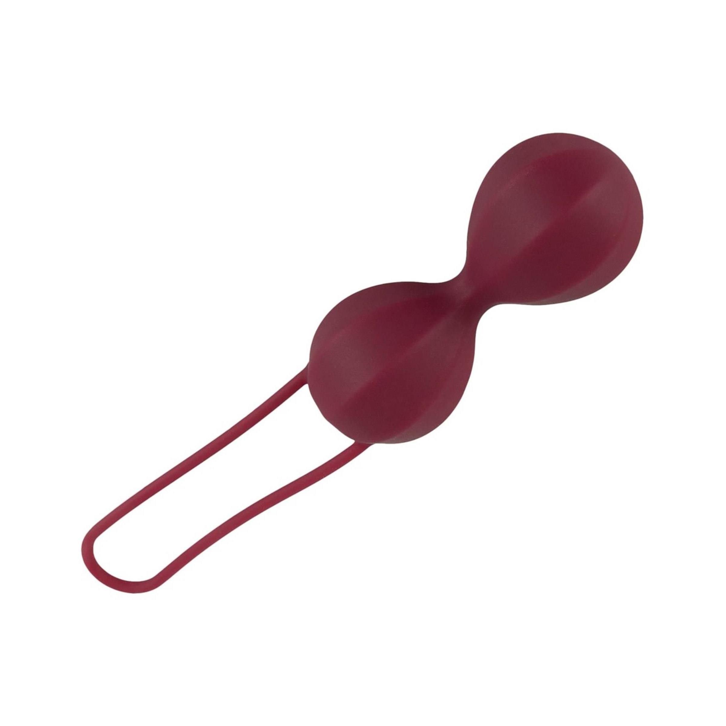 Burgunderfarbene Liebeskugel mit zwei Kugeln und einer Schlaufe. Oberfläche mit Rillen. Auf weißem Hintergrund.