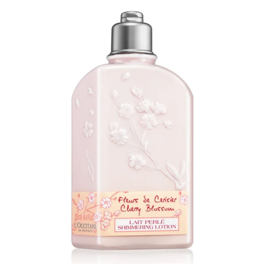 Rosa Flasche mit Blütenrelief und silbernem Verschluss. Aufschrift: Fleur de Cerisier Cherry Blossom, Lait Perlé Shimmering Lotion.