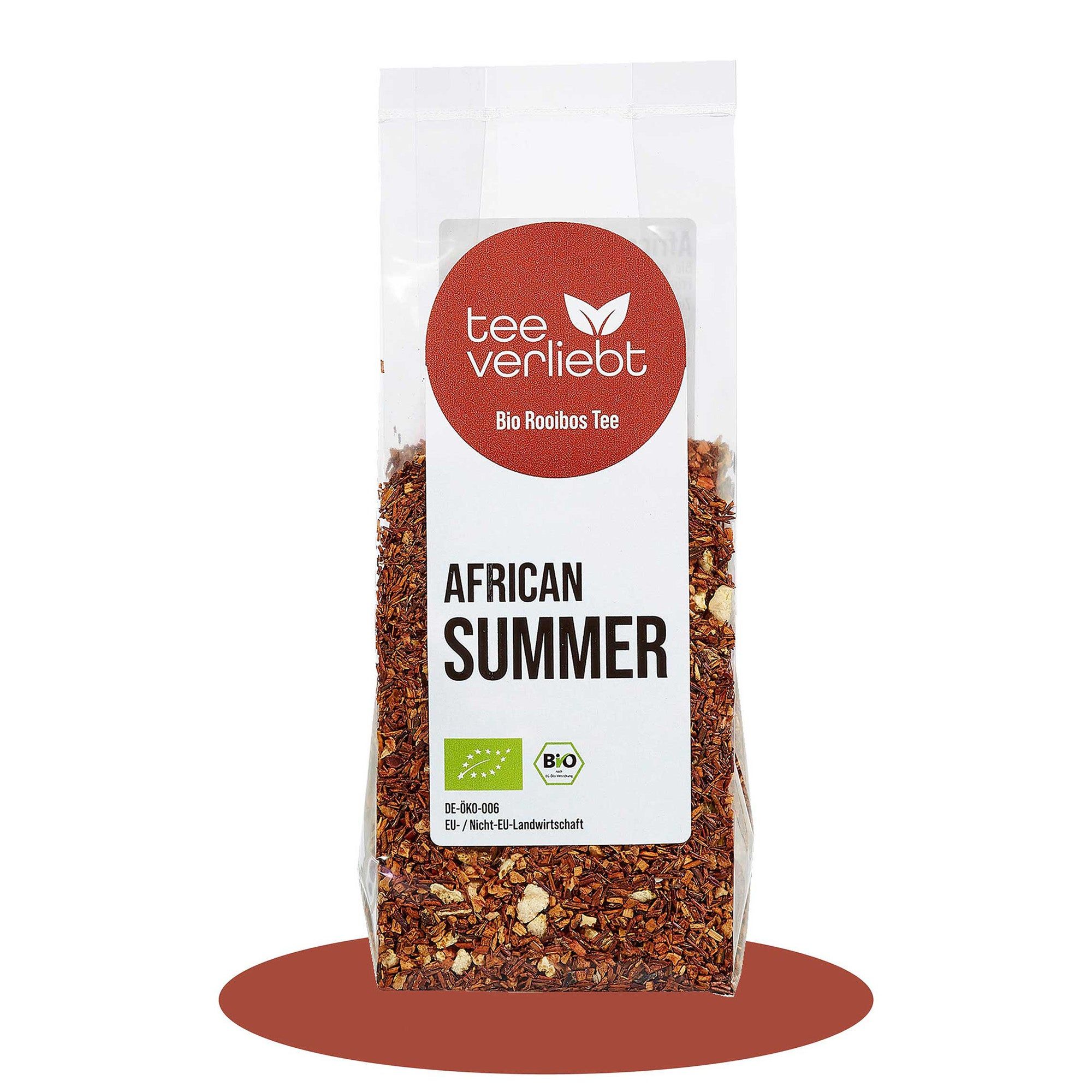 Transparente Beutel mit losem Rooibostee. Roter Aufkleber mit "tee verliebt" und "Bio Rooibos Tee". Text: "AFRICAN SUMMER". Bio-Siegel.