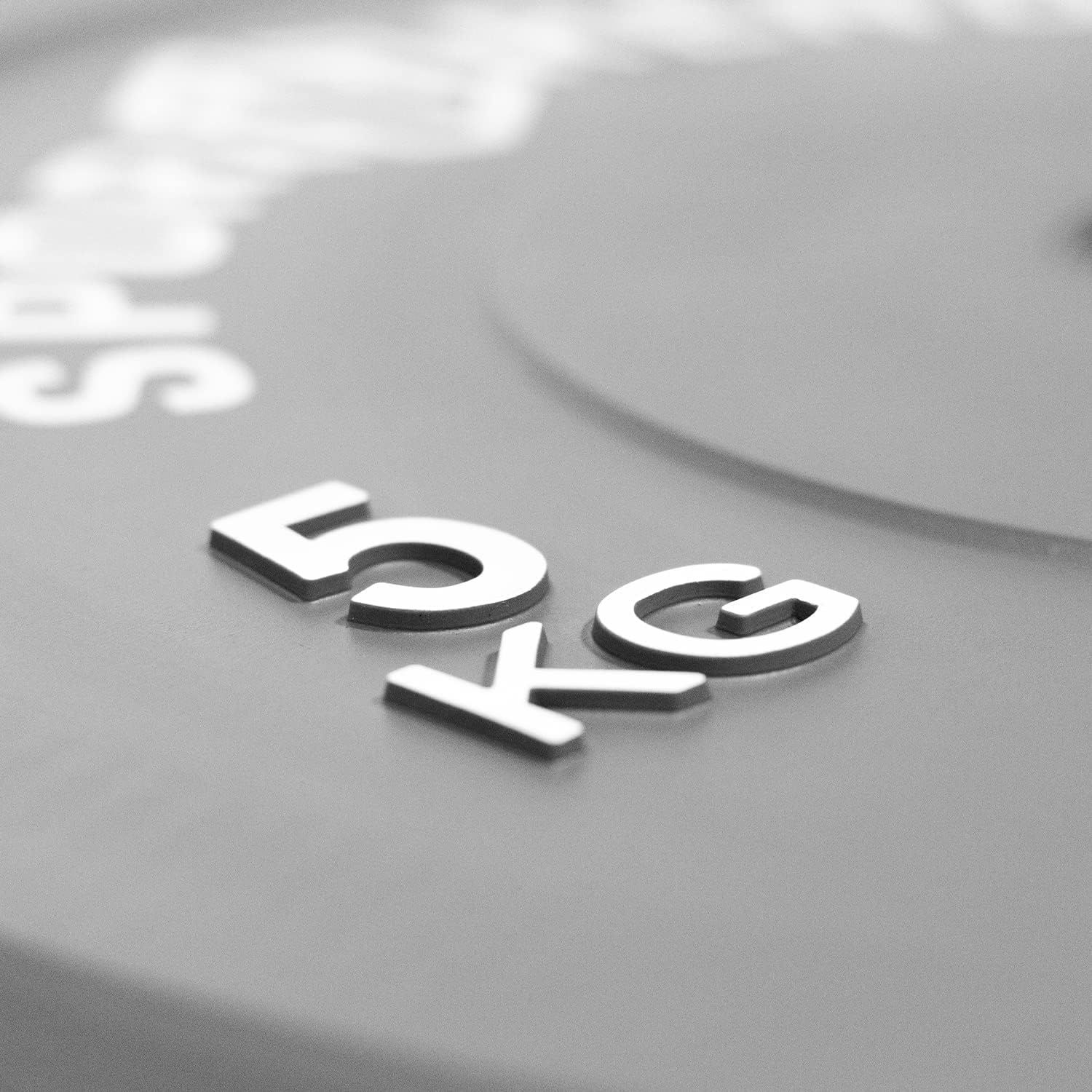 Graue Bumper Plate mit weißem Schriftzug 5 KG. Nahaufnahme.