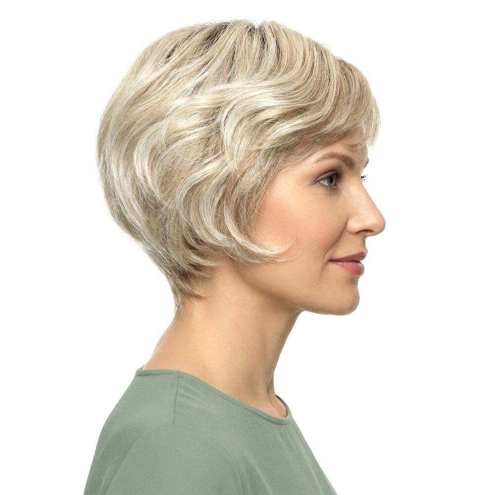 Kurzhaarperücke mit blonden Locken. Seitenansicht einer Frau mit grünem Oberteil.