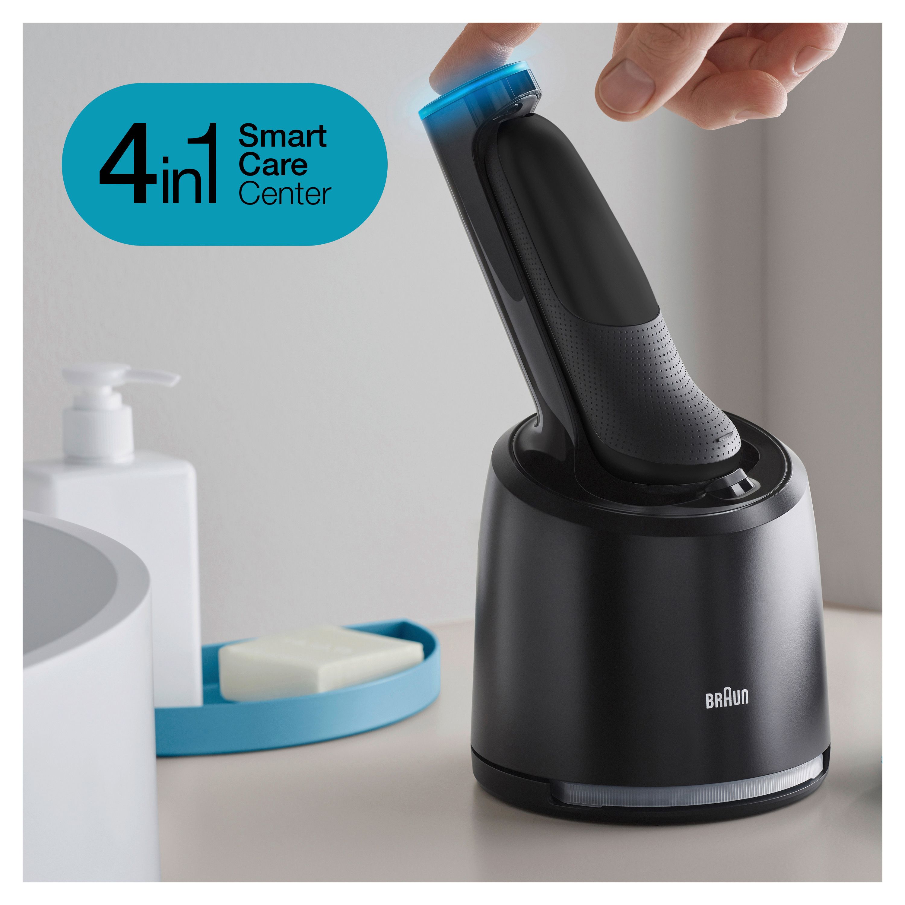 Schwarzer Rasierer in Ladestation. Blaue LED-Beleuchtung. Aufschrift "Braun". Neben Seife und Spender.