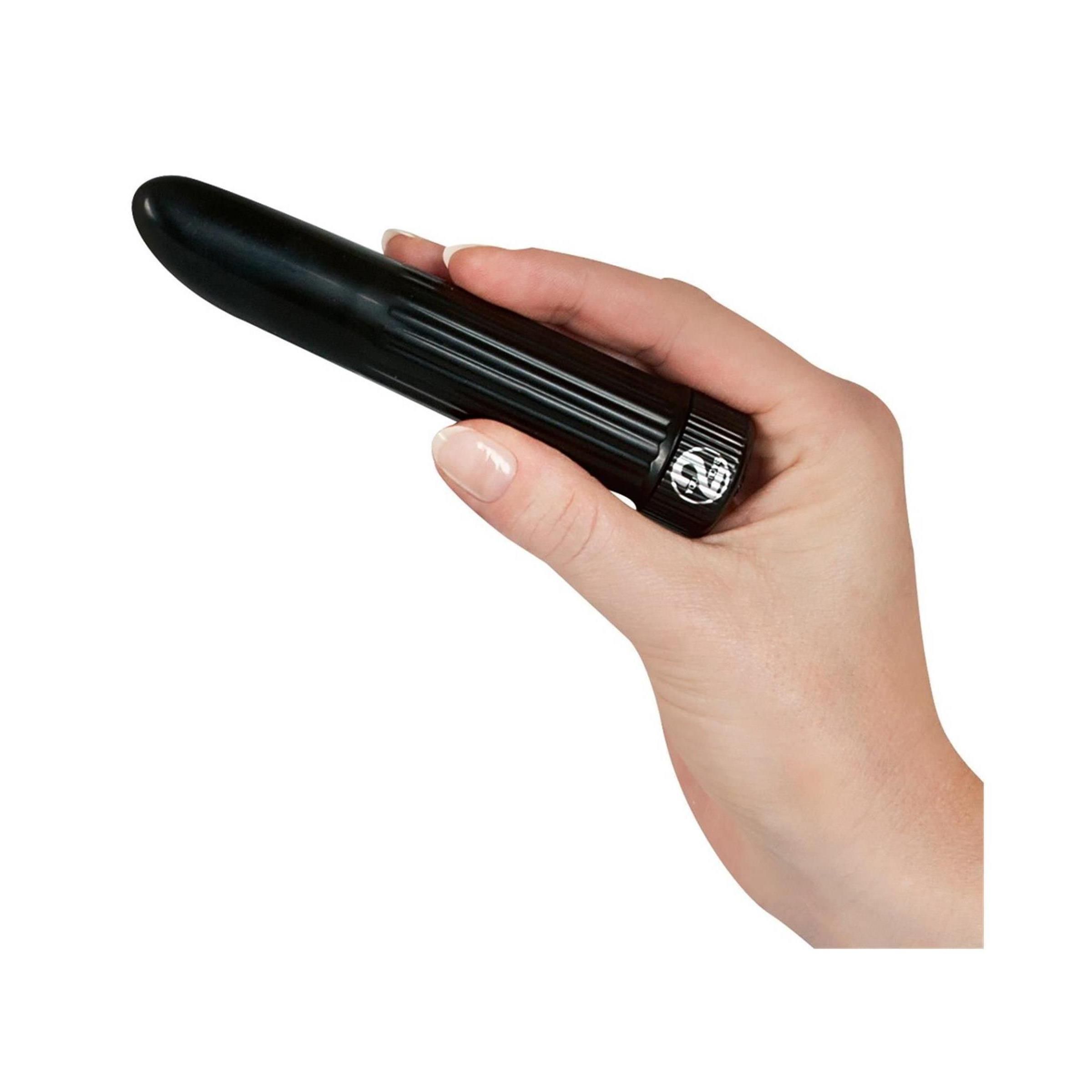 Schwarzer Vibrator in einer Hand gehalten. Geriffelte Oberfläche, abgerundete Spitze, Basis mit Logo.
