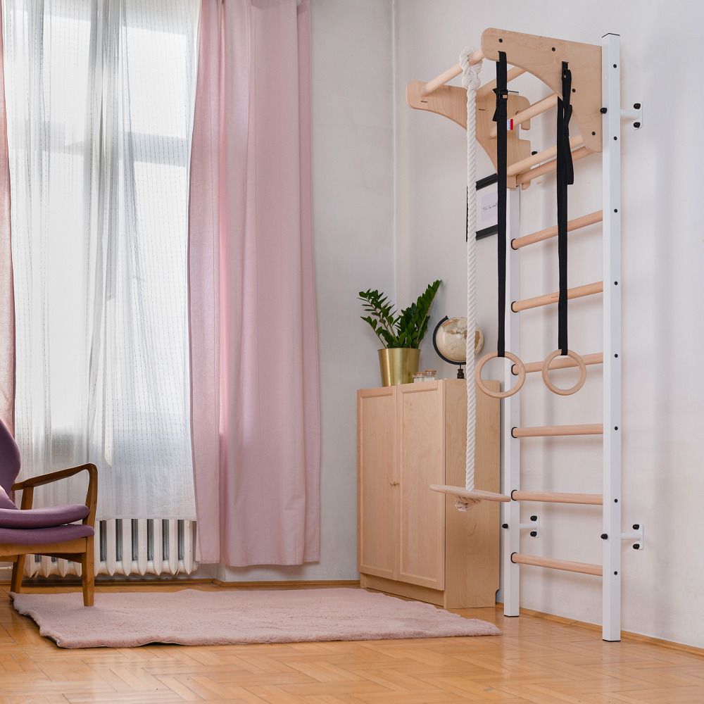 Sprossenwand mit Turnzubehör. Holz- und Metallkonstruktion. Ringe, Seil und Klimmzugstange. An der Wand montiert.
