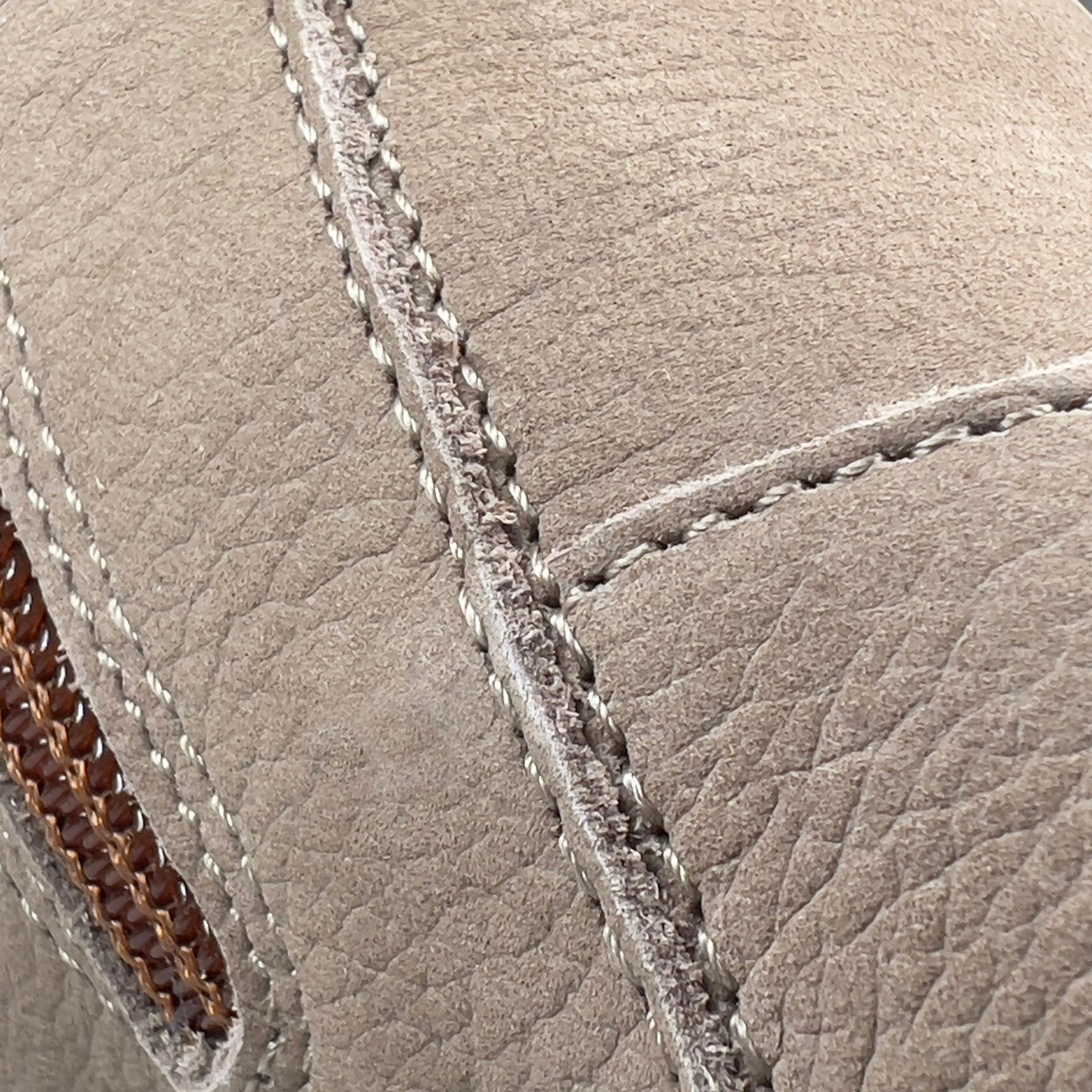 Nahaufnahme der Schuhstruktur. Beige Leder mit sichtbaren Nähten und Reißverschluss.