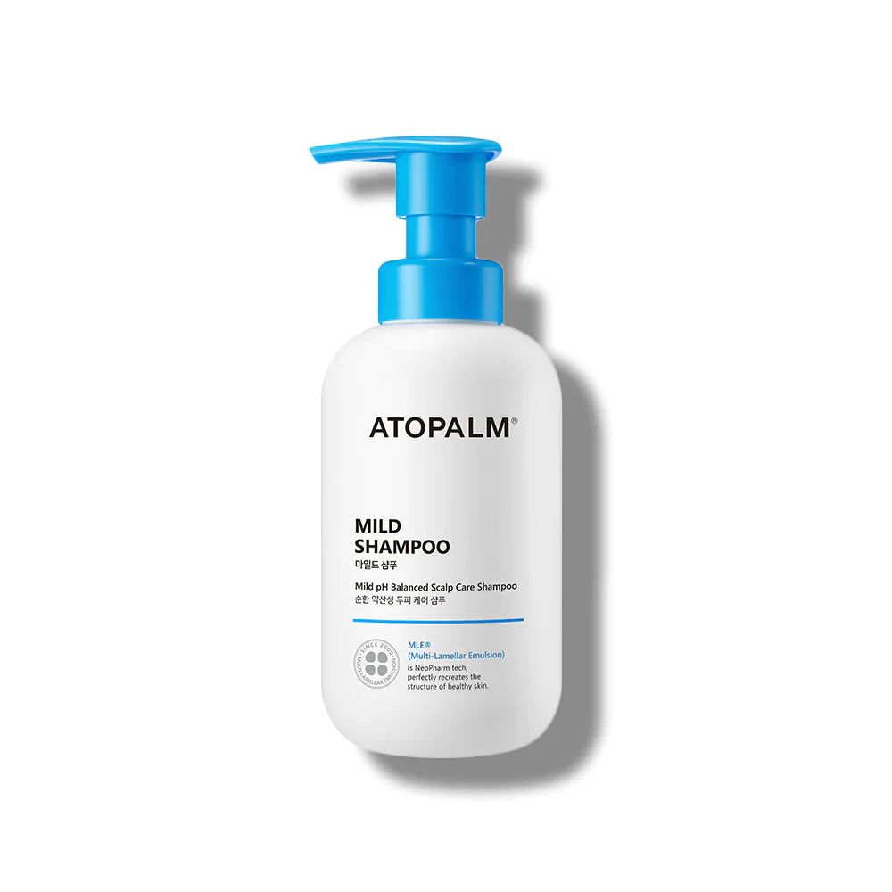 Weiße Flasche mit blauem Pumpkopf. Aufschrift ATOPALM, MILD SHAMPOO. Produkt für empfindliche Kopfhaut. Mit Zertifizierungen.